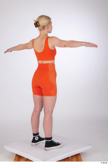 Unaisa dressed orange bike shorts orange sports bra standing t-pose…